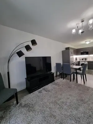 a living room with a tv and a table and chairs at Palm beach apartment with swimming pool in a residence in Cannes