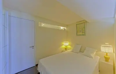 a white bedroom with a white bed and a lamp at Luxueux 3 Chambres Terrasse de 90m hypercentre - Wifi Clim - 6 pers in Cannes
