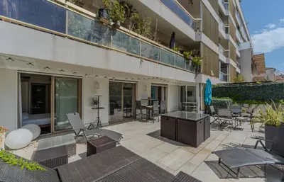 an outdoor patio with chairs and tables and a building at Luxueux 3 Chambres Terrasse de 90m hypercentre - Wifi Clim - 6 pers in Cannes