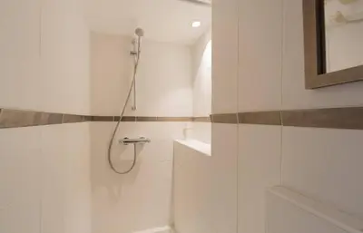 a white bathroom with a shower and a sink at Luxueux 3 Chambres Terrasse de 90m hypercentre - Wifi Clim - 6 pers in Cannes