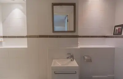 a white bathroom with a sink and a mirror at Luxueux 3 Chambres Terrasse de 90m hypercentre - Wifi Clim - 6 pers in Cannes