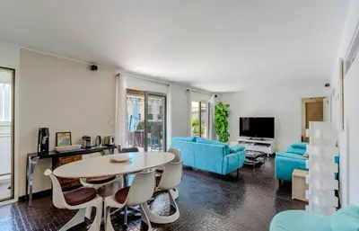 a living room with a table and a blue couch at Luxueux 3 Chambres Terrasse de 90m hypercentre - Wifi Clim - 6 pers in Cannes