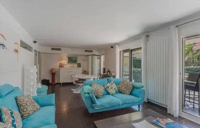 a living room with blue couches and a kitchen at Luxueux 3 Chambres Terrasse de 90m hypercentre - Wifi Clim - 6 pers in Cannes