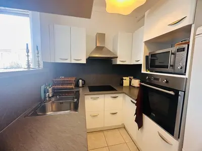 a kitchen with white cabinets and a sink and a microwave at Bright one bedroom apartment in the center of Cannes13 minutes walk to the Palais des Festivals - 2290 in Cannes
