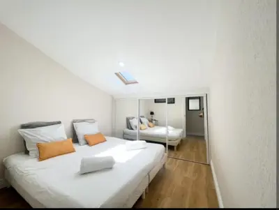 a white bedroom with a large bed and a mirror at Appartement, proche du palais des festivals, plage et commerces in Cannes