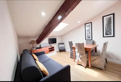 a living room with a couch and a dining room table at Appartement, proche du palais des festivals, plage et commerces in Cannes