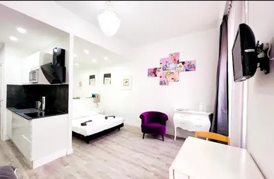 a white bathroom with a purple chair and a sink at Studio moderne et calme en plein centre in Cannes