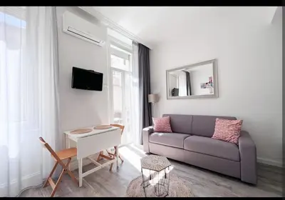 a living room with a couch and a table at Studio moderne et calme en plein centre in Cannes