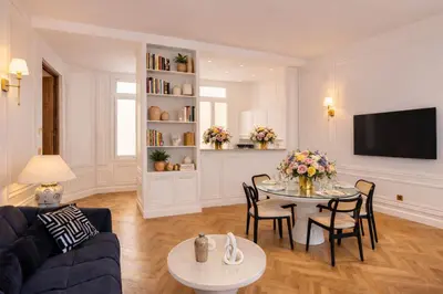 a living room with a table and a blue couch at Le Suite Napoléon - Luxe et Sérénité au Cœur de Cannes in Cannes