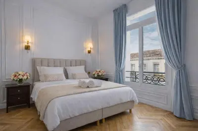 a living room with a couch and a table at Le Suite Napoléon - Luxe et Sérénité au Cœur de Cannes in Cannes