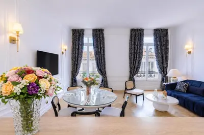 a bedroom with a large bed with white sheets and pillows at Le Suite Napoléon - Luxe et Sérénité au Cœur de Cannes in Cannes
