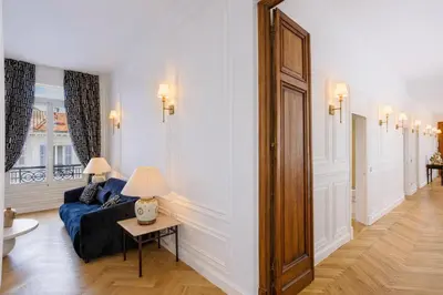 a bedroom with a bed and a desk and a window at Le Suite Napoléon - Luxe et Sérénité au Cœur de Cannes in Cannes