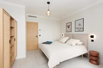 a white bedroom with a bed and a closet at Sublime appartement Forville Festival in Cannes
