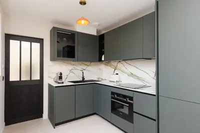 a kitchen with black cabinets and a sink at Sublime appartement Forville Festival in Cannes