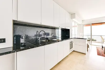 a kitchen with white cabinets and black counter tops at Immogroom- 2 bedrooms -Panoramic Sea view - Huge in Cannes