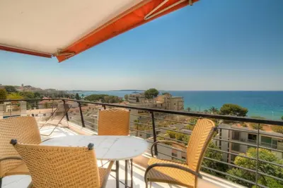 a balcony with a table and chairs and the ocean at Immogroom- 2 bedrooms -Panoramic Sea view - Huge in Cannes