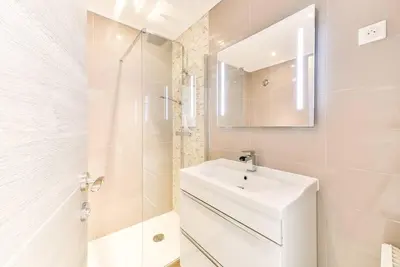 a white bathroom with a sink and a mirror at Immogroom- 2 bedrooms -Panoramic Sea view - Huge in Cannes