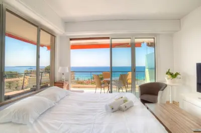 a bedroom with a large bed with a view of the ocean at Immogroom- 2 bedrooms -Panoramic Sea view - Huge in Cannes