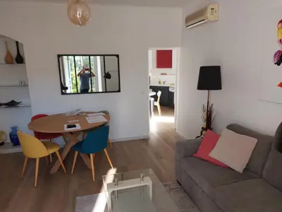 a living room with a table and a couch at Cannes centre avec parking et jardin in Cannes