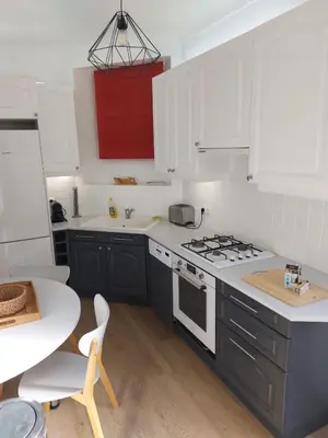 a kitchen with white cabinets and a stove top oven at Cannes centre avec parking et jardin in Cannes
