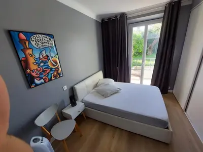a small bedroom with a bed and a window at Cannes centre avec parking et jardin in Cannes