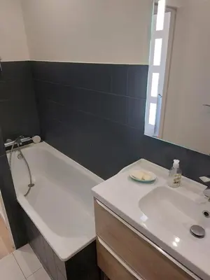 a bathroom with a white tub and a sink at Cannes centre avec parking et jardin in Cannes