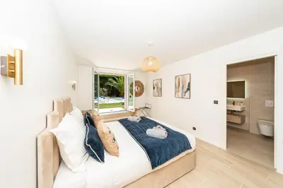 a bedroom with a large bed and a bathroom at Luxury Villa Cannes,350 m2, 12 pers, 6 ch 6 sdb in Cannes