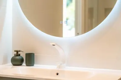 a bathroom sink with a round mirror above it at Luxury Villa Cannes,350 m2, 12 pers, 6 ch 6 sdb in Cannes