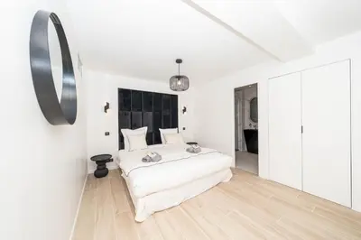 a white bedroom with a white bed and a mirror at Luxury Villa Cannes,350 m2, 12 pers, 6 ch 6 sdb in Cannes
