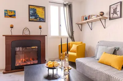a living room with a fireplace and a couch at Comfortable apartment in the heart of Suquet in Cannes