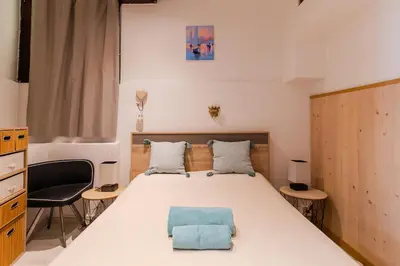 a bedroom with a bed with a blue pillow on it at Comfortable apartment in the heart of Suquet in Cannes
