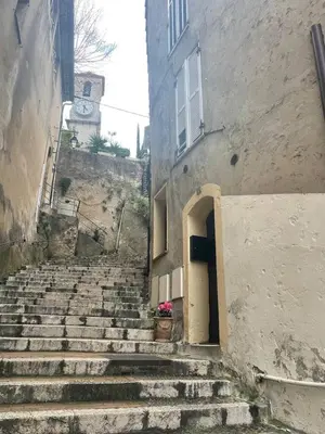 a set of stairs leading up to a building with a door at Comfortable apartment in the heart of Suquet in Cannes