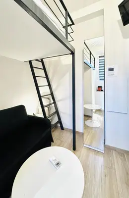 a living room with a black couch and a table at Croisette Studio, Palais des Festivals and Beach in Cannes