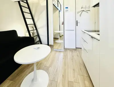 a living room with a white table and a kitchen at Croisette Studio, Palais des Festivals and Beach in Cannes