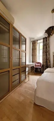 a bedroom with glass doors and a bed and a desk at Newly renovated 3-rooms apartment in the heart of old Cannes, up to 6 persons in Cannes