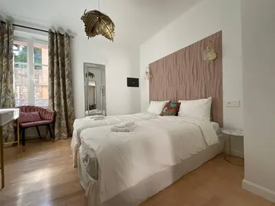 a bedroom with a large white bed and a desk at Newly renovated 3-rooms apartment in the heart of old Cannes, up to 6 persons in Cannes