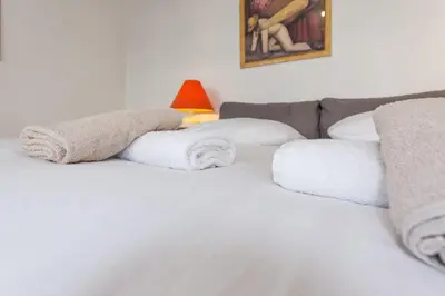 a white bed with towels on top of it at Le Vendôme - Hypercentre - AC - Terrace - Palais of Festivals - Croisette in Cannes