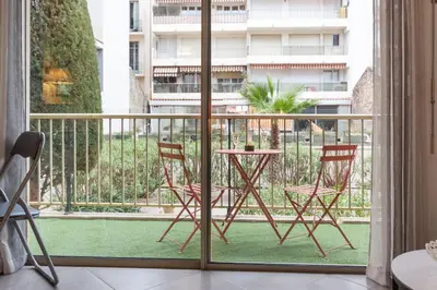 a balcony with two chairs and a table on a porch at Le Vendôme - Hypercentre - AC - Terrace - Palais of Festivals - Croisette in Cannes