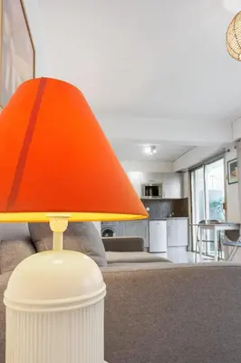 an orange lamp on a table in a living room at Le Vendôme - Hypercentre - AC - Terrace - Palais of Festivals - Croisette in Cannes