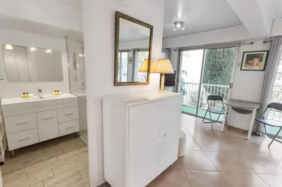 a white bathroom with two sinks and a mirror at Le Vendôme - Hypercentre - AC - Terrace - Palais of Festivals - Croisette in Cannes