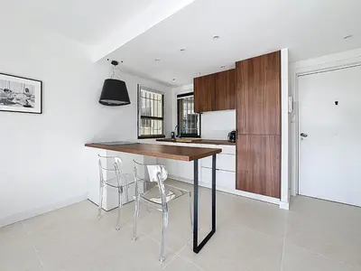 a kitchen with a table and chairs in a room at 2 pièces vue mer, piscine, à 2 pas des plages in Cannes