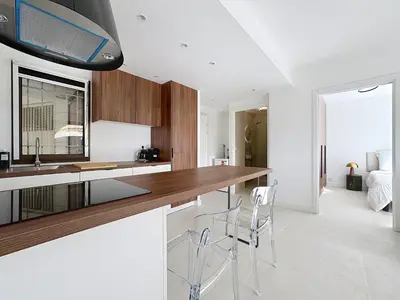 a kitchen with a counter and two stools at 2 pièces vue mer, piscine, à 2 pas des plages in Cannes