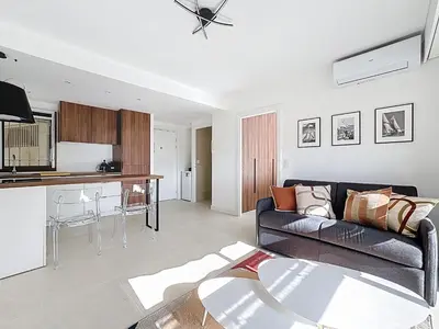 a living room with a couch and a table at 2 pièces vue mer, piscine, à 2 pas des plages in Cannes