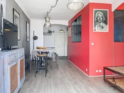 a dining room with a red wall and a table at Le Félix - 4 pers 66 m2 - Vieux port - Climatisation in Cannes