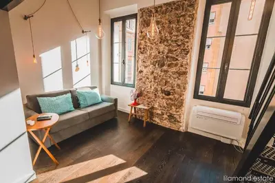 a living room with a couch and some windows at Studio City Center W Mezzanine 5min From Palace in Cannes