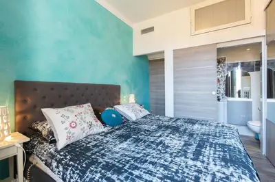 a bedroom with a bed with a blue wall at Charmant appartement à 5min du Palais des Festivals in Cannes