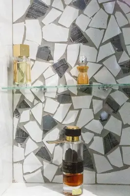 a glass shelf with two bottles of essential oils on it at Charmant appartement à 5min du Palais des Festivals in Cannes