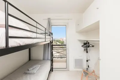 a bedroom with a bunk bed and a balcony at Cannes Beach - Vue Mer-Plage-Piscine-Clim-Wifi in Cannes
