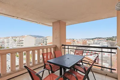 a table and chairs on a balcony with a view at Cannes Beach - Vue Mer-Plage-Piscine-Clim-Wifi in Cannes