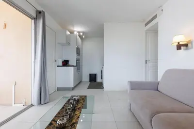 a living room with a couch and a glass table at Cannes Beach - Vue Mer-Plage-Piscine-Clim-Wifi in Cannes